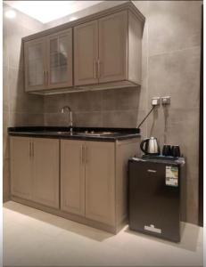 a kitchen with wooden cabinets and a sink and a refrigerator at شقة فندقية فاخرة in Taif