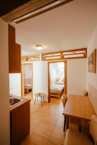 a kitchen with a table and a dining room at Prenočište M & S in Valpovo