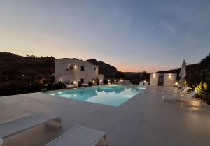 a large swimming pool with chairs and a building at ACQUA PETRA Pool Villa & Suites in Agrigento