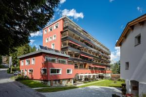 a tall red building with a black at Blatter's Arosa Hotel & Bella Vista SPA in Arosa
