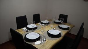 a wooden table with plates and wine glasses on it at Refúgio da Azinheira in Torrão
