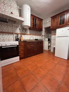 a kitchen with white appliances and a tile floor at Refúgio da Azinheira in Torrão