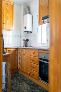 a kitchen with wooden cabinets and a stove at Casa El Pilar in Serón