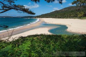 a beach with a group of people walking on it at Casa Tamiván in Muxia