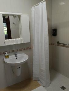 a bathroom with a sink and a white shower curtain at Casa Tamiván in Muxia +6 photos