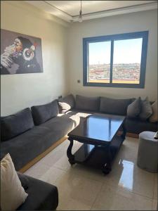 a living room with a couch and a coffee table at Appart 5min plage, plein centre in Sidi Rahal