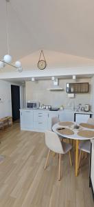 a kitchen with a table and chairs in a room at Domek na górce u Ani in Polanowo