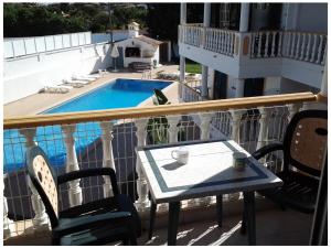a table and chairs on a balcony with a pool at Resort Solar Veiguinha in Carvoeiro
