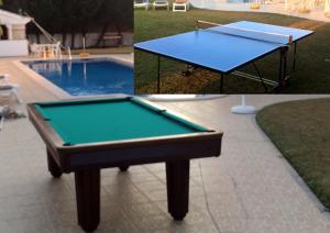 a pool table sitting next to a swimming pool at Resort Solar Veiguinha in Carvoeiro