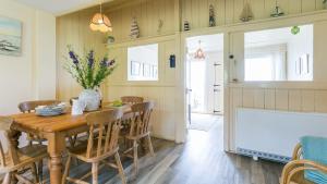 a dining room with a wooden table and chairs at Beach Bungalow in Nefyn