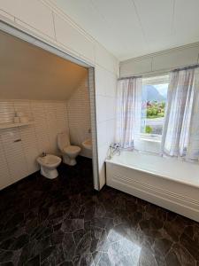 a bathroom with two toilets and a tub and a window at ROOMS by Ramberg Beach in Ramberg