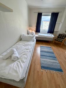 a room with two beds and a window at ROOMS by Ramberg Beach in Ramberg