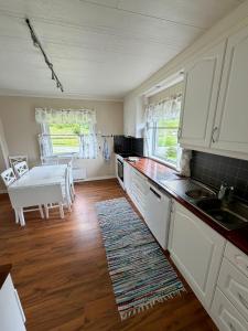 a kitchen with white cabinets and a table and a sink at ROOMS by Ramberg Beach in Ramberg +4 photos