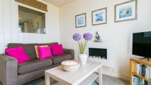 a living room with a couch and a tv at Beach Bungalow in Nefyn
