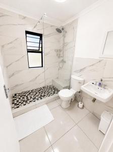 a white bathroom with a toilet and a sink at Unit 5 in Serengeti Complex, Bloemhof, Bellville in Blomtuin
