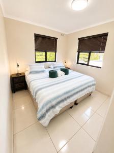 a large white bed in a bedroom with two windows at Unit 5 in Serengeti Complex, Bloemhof, Bellville in Blomtuin