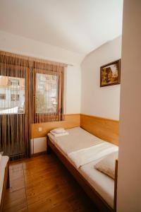a small room with a bed and a window at Prenočište M & S in Valpovo
