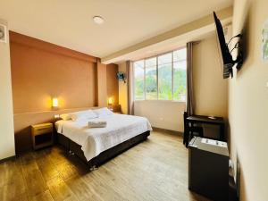 a bedroom with a bed and a large window at La Posada del Pastor in Tarapoto