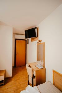 a room with a table and a bed and a mirror at Prenočište M & S in Valpovo