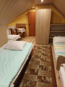 a room with two beds and a dining room with a table at Kwatery u Potoków in Piwniczna-Zdrój