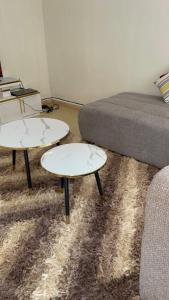 ein Wohnzimmer mit zwei Tischen und einem Sofa in der Unterkunft Kitale Comfy in Kitale + 2 Fotos