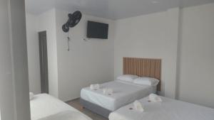 a room with two beds and a flat screen tv at Hotel Boutique 1801 in San Juan de Rioseco  +8 photos