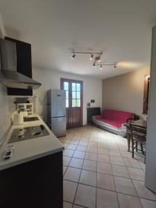 a kitchen with a refrigerator and a room with a bed at La Casina in Pontedera