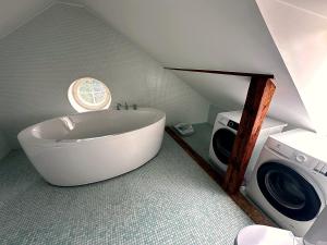 a bathroom with a tub and a washing machine at Cathedral Apartment Tartu in Tartu +9 photos