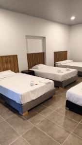 three beds sitting in a room with a tiled floor at Hotel Boutique 1801 in San Juan de Rioseco 