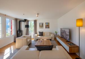 a living room with white furniture and a table at Chalet Mittaghorn Apt 7 in Wengen