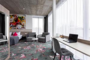 een kamer met een bureau met een laptop en stoelen bij Algiro Hotel in Kaunas