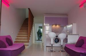 a living room with purple furniture and a staircase at Aydos Suites in Dalyan