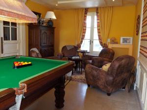 a living room with a pool table and chairs at MAISON d HOTES in May-sur-Orne