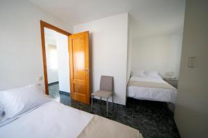 a bedroom with two beds and a chair in it at Casa El Pilar in Serón