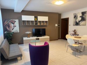 a living room with a couch and a tv and a table at Casa Margot in Villaverla