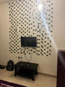 a living room with a tv and a table at Trydan room stay in Chengalpattu