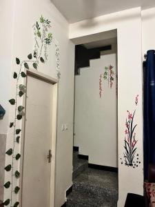 a hallway with a door with flowers on the wall at Trydan room stay in Chengalpattu