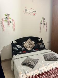a bedroom with a bed with pillows and flowers on the wall at Trydan room stay in Chengalpattu