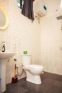 a bathroom with a white toilet and a sink at Karibu House Paje in Paje +73 photos