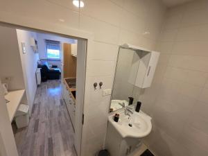 a white bathroom with a sink and a mirror at apartmani mikek in Domaslovec +12 photos