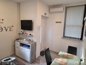 a living room with a table and a tv on the wall at apartmani mikek in Domaslovec