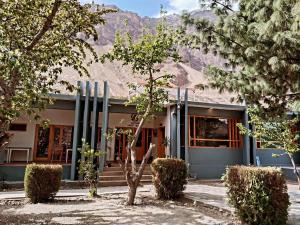 a building with a mountain in the background at Hunza Oriole Hotel in Alīābād