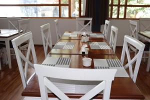 a dining room with a white table and chairs at Hunza Oriole Hotel in Alīābād