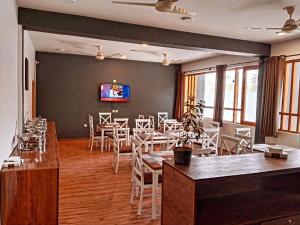 a dining room with tables and chairs and a tv at Hunza Oriole Hotel in Alīābād