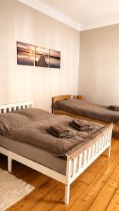 two beds in a room with wooden floors at Pension zum Ziegenbart in Tangermünde