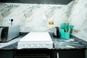 a kitchen with a counter top with a white stove at Famous Apartments in Ologode