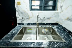 a washing machine in a sink in a bathroom at Famous Apartments in Ologode