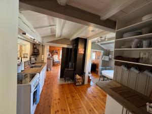 a kitchen with white appliances and a wooden floor at Atmospheric cabin by Lesjaskogsvatnet in Lesja +7 photos