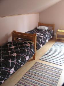 1 Schlafzimmer mit 2 Betten und einem Teppich in der Unterkunft Majatalo Tyrni in Nakkila