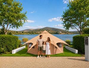 Eine Familie steht vor einem Zelt in der Unterkunft Anna Glamping in Fuen Negra